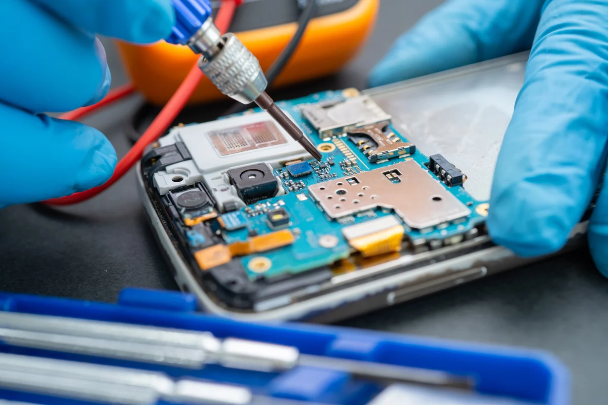 Technician Repairing inside of Mobile Phone by Soldering Iron. I